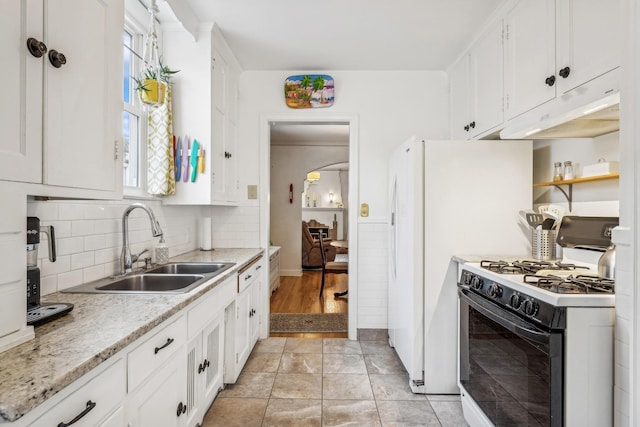 kitchen with sink, white cabinets, white gas range oven, and backsplash