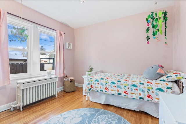 bedroom featuring hardwood / wood-style floors and radiator