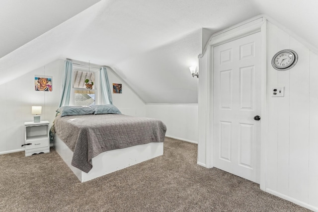 bedroom featuring lofted ceiling and dark colored carpet