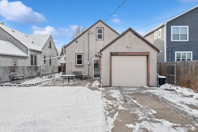 snow covered house featuring a garage