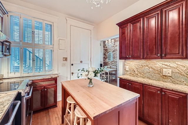 442 Summit Ave Unit 6, Saint Paul, MN 55102 - kitchen featuring dark brown cabinets, stainless steel appliances, backsplash, and light wood finished floors