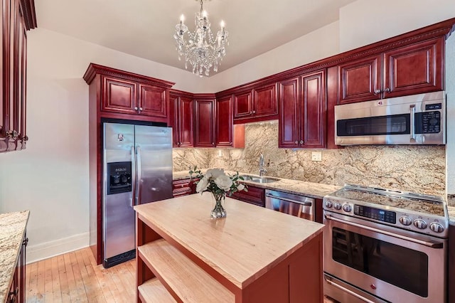 442 Summit Ave Unit 6, Saint Paul, MN 55102 - kitchen featuring appliances with stainless steel finishes, dark brown cabinets, a chandelier, tasteful backsplash, and light wood-style flooring