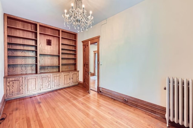 442 Summit Ave Unit 6, Saint Paul, MN 55102 - unfurnished room with radiator heating unit, a chandelier, and light wood finished floors