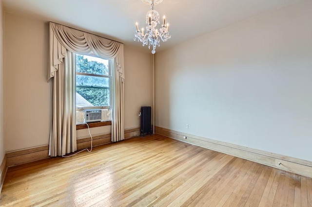 442 Summit Ave Unit 6, Saint Paul, MN 55102 - spare room featuring cooling unit, light wood-type flooring, a chandelier, and radiator heating unit