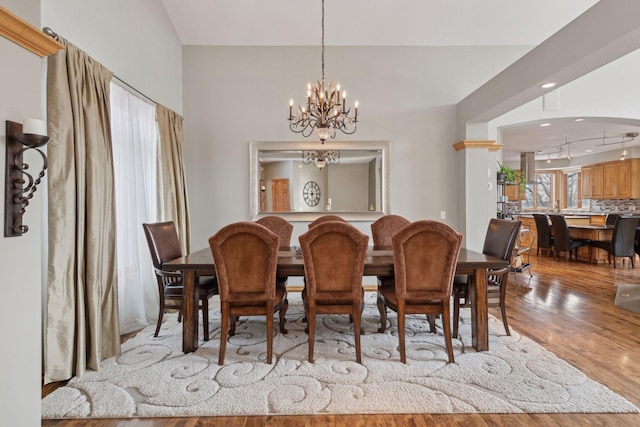 dining area with light hardwood / wood-style flooring and a notable chandelier