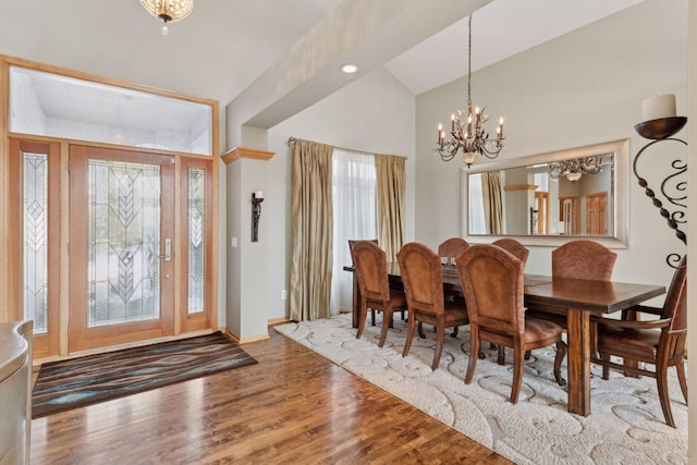 dining room with hardwood / wood-style flooring, lofted ceiling, and a chandelier