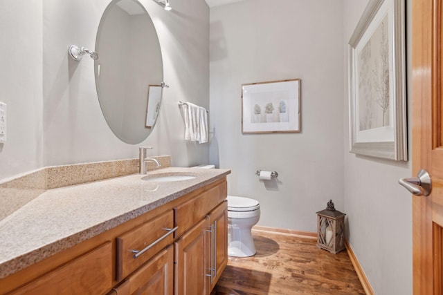 bathroom featuring hardwood / wood-style flooring, vanity, and toilet