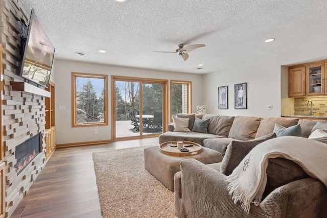 living room featuring hardwood / wood-style floors, a textured ceiling, and ceiling fan