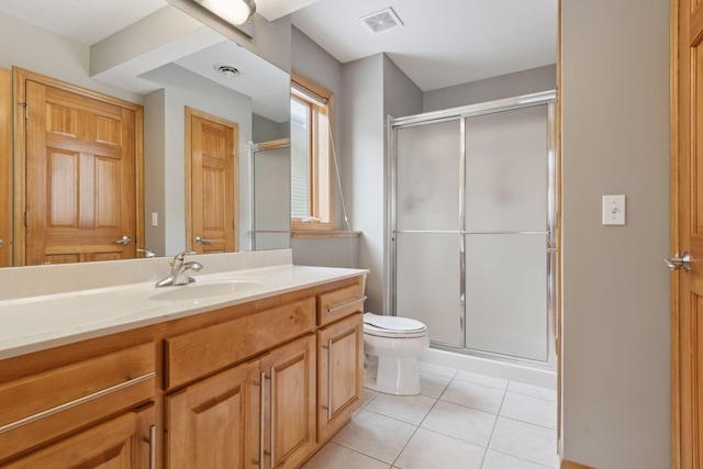 bathroom featuring tile patterned flooring, vanity, an enclosed shower, and toilet