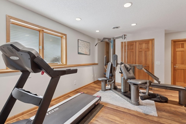 workout area with wood-type flooring and a textured ceiling