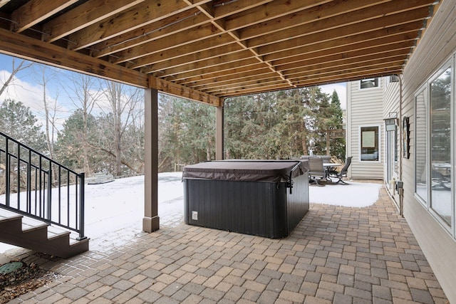 snow covered patio featuring a hot tub