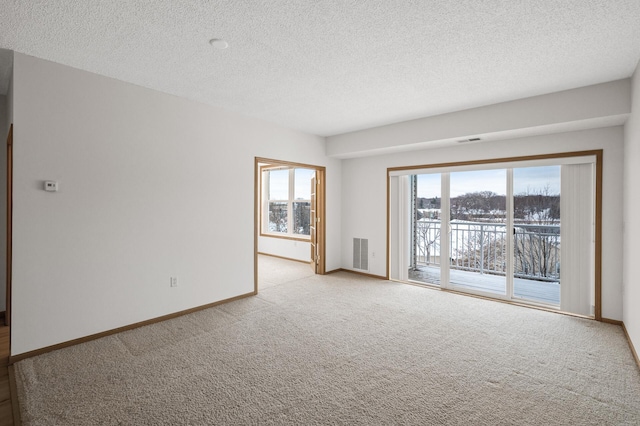 empty room featuring a textured ceiling and light carpet