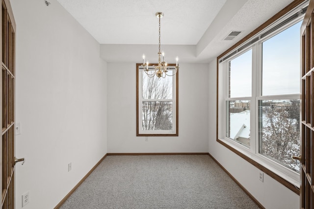 unfurnished room with carpet floors and a chandelier