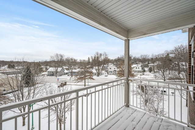 view of snow covered back of property