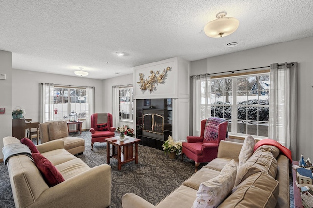 living room with a tile fireplace and a textured ceiling