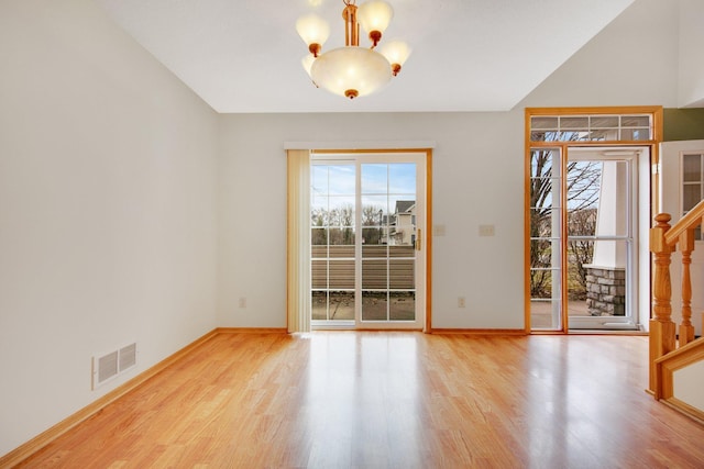 interior space featuring visible vents, a notable chandelier, wood finished floors, and a healthy amount of sunlight