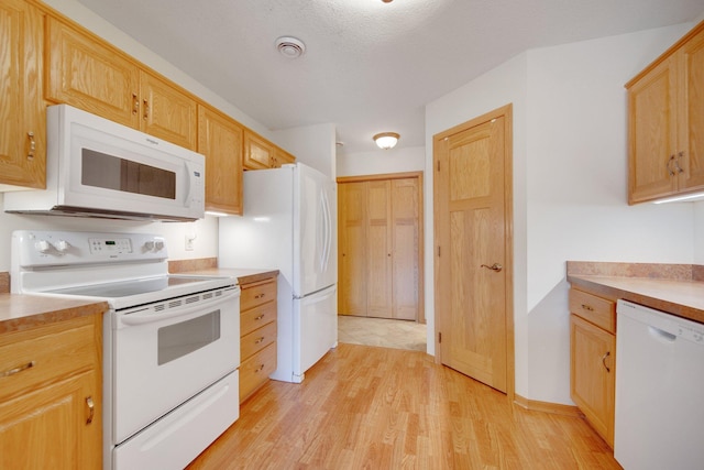 kitchen featuring light wood-style floors, white appliances, visible vents, light countertops, and light brown cabinets