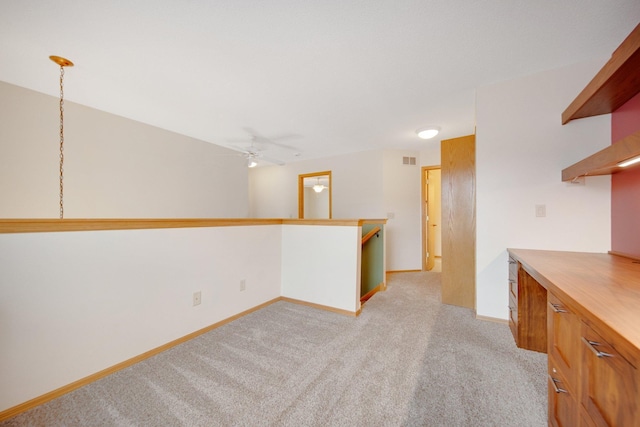spare room featuring visible vents, ceiling fan, light colored carpet, and baseboards