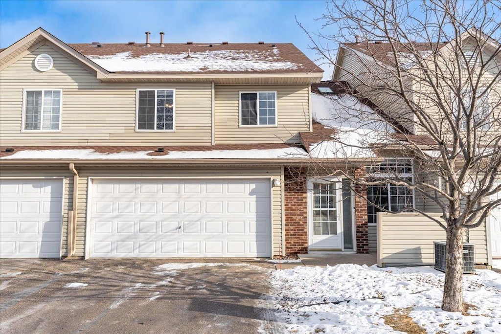 view of front of house with a garage and central air condition unit