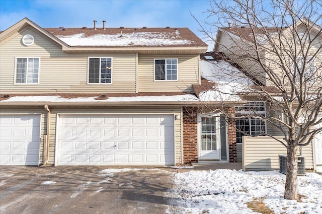 view of front of house with a garage and central air condition unit