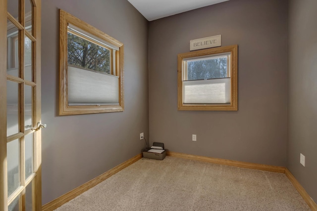 spare room featuring carpet floors and baseboards