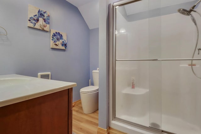 bathroom with a shower with door, visible vents, toilet, vanity, and wood finished floors