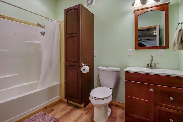 bathroom with visible vents, toilet, shower / tub combo, vanity, and wood finished floors