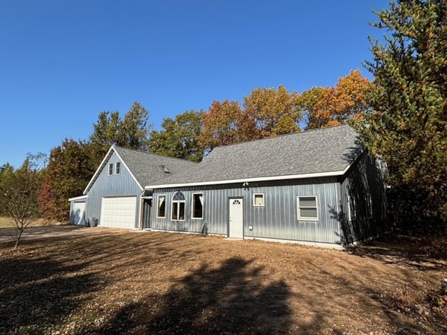 ranch-style home with roof with shingles