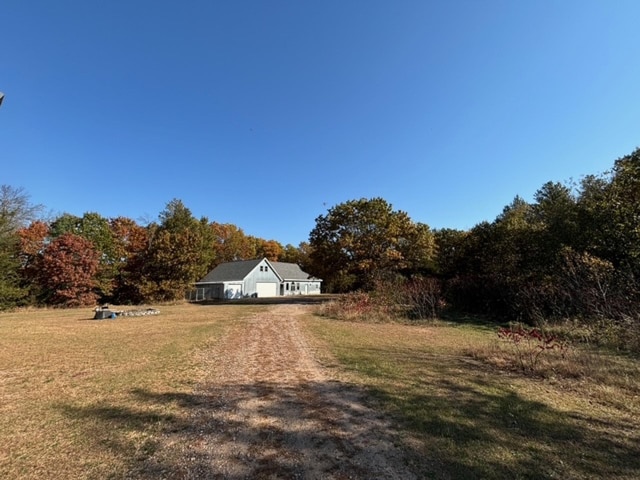 N1865 980th St, Rock Creek Twp, WI 54701 - view of front of house with dirt driveway and a front lawn