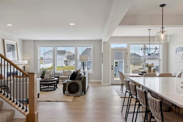 interior space featuring plenty of natural light, a chandelier, a textured ceiling, and light wood-type flooring