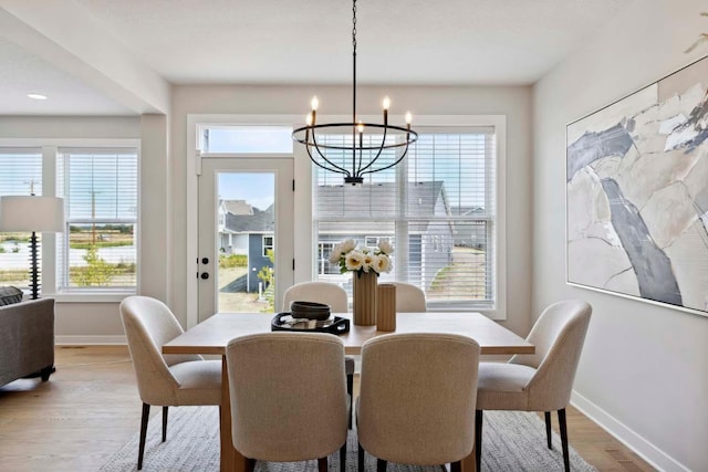 dining area featuring a chandelier, light hardwood / wood-style floors, and a wealth of natural light