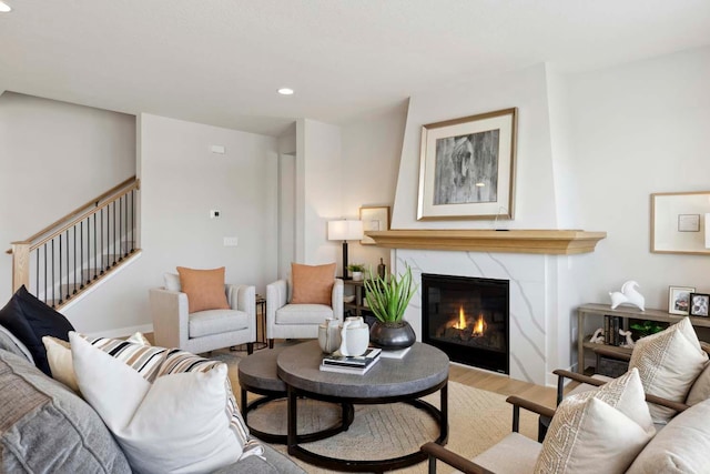 living room featuring a high end fireplace and hardwood / wood-style flooring