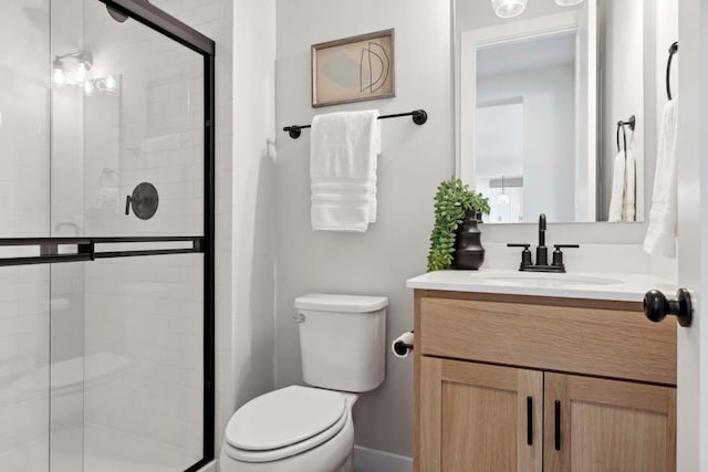 bathroom with an enclosed shower, vanity, and toilet