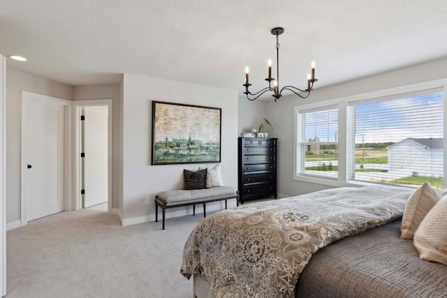 carpeted bedroom with a textured ceiling and an inviting chandelier