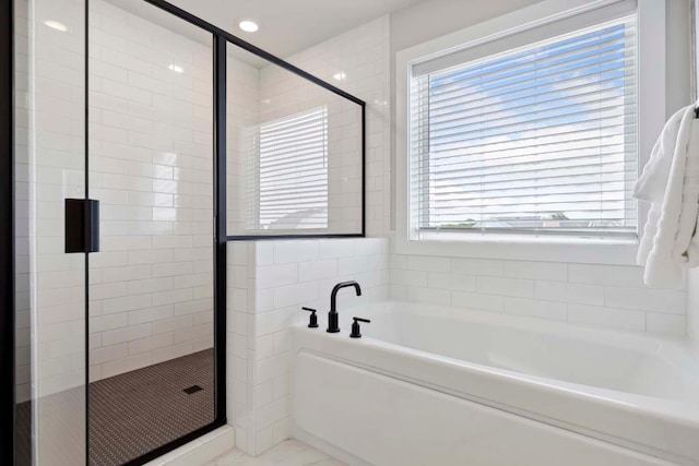 bathroom featuring shower with separate bathtub and a wealth of natural light