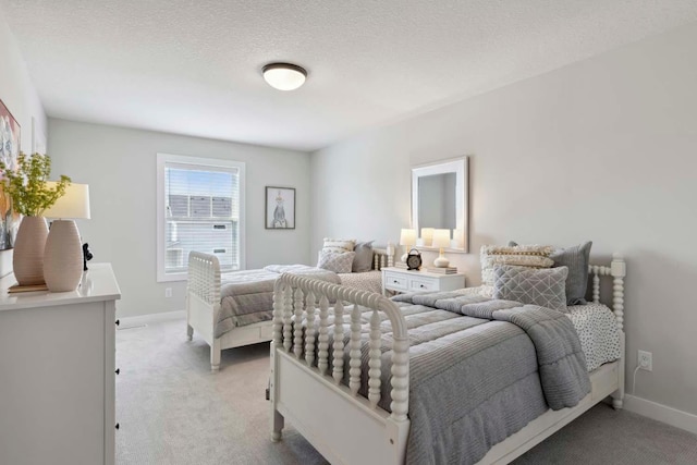 bedroom with light colored carpet and a textured ceiling