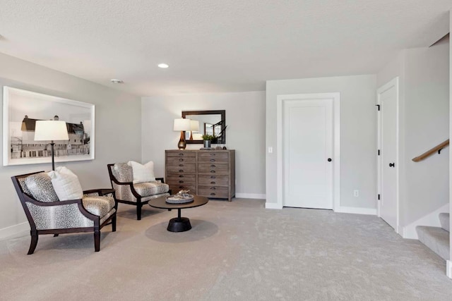 living area with a textured ceiling and light carpet