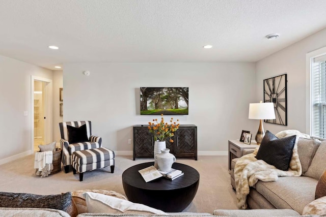 living room with a textured ceiling and light colored carpet