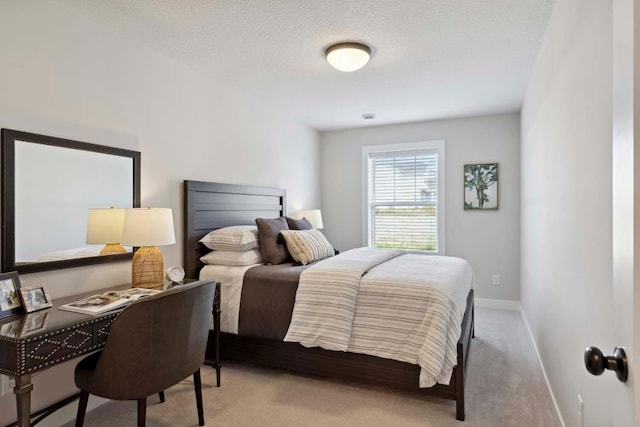 bedroom with a textured ceiling and light carpet