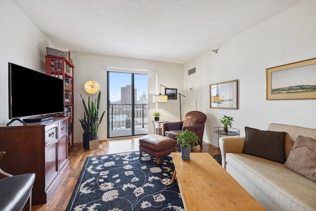 living room with light wood-type flooring and a textured ceiling