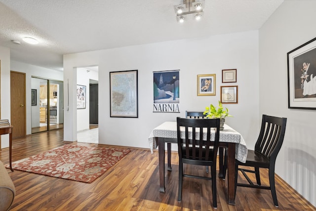 dining area with a textured ceiling and hardwood / wood-style flooring