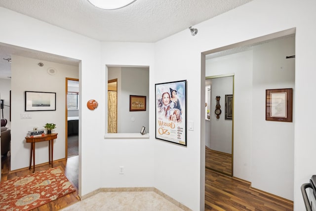 hall featuring dark hardwood / wood-style flooring and a textured ceiling