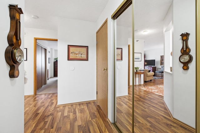 corridor featuring dark hardwood / wood-style flooring and a textured ceiling