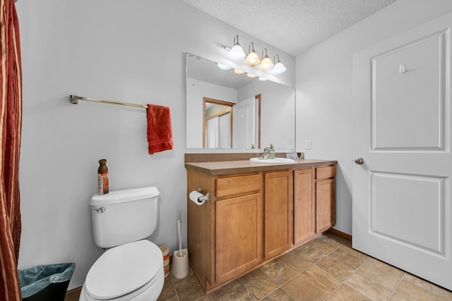 bathroom featuring toilet, vanity, and a textured ceiling