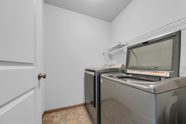 laundry room with a textured ceiling and separate washer and dryer