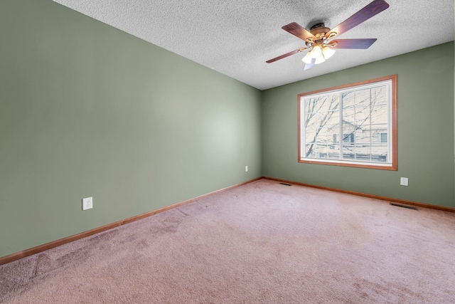 carpeted empty room with ceiling fan and a textured ceiling