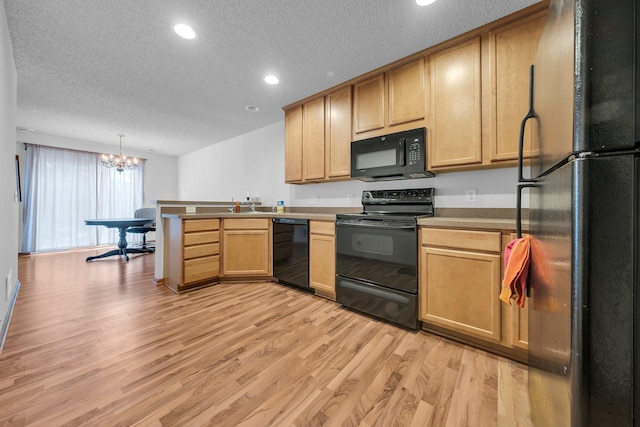 kitchen featuring a textured ceiling, light hardwood / wood-style flooring, hanging light fixtures, a notable chandelier, and black appliances