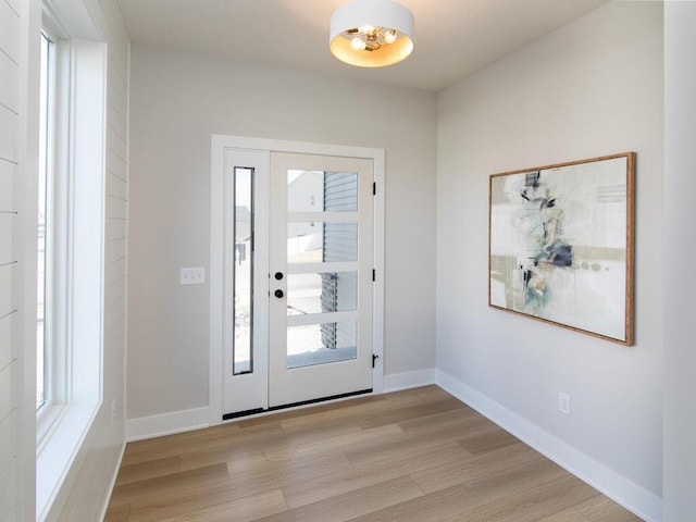 entryway featuring baseboards and light wood-style floors