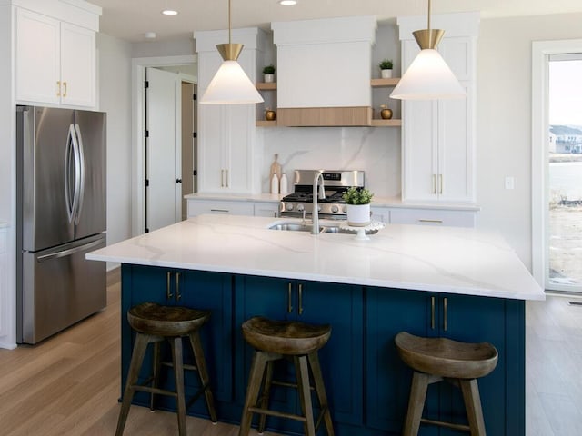 kitchen featuring backsplash, light wood-type flooring, appliances with stainless steel finishes, white cabinets, and open shelves