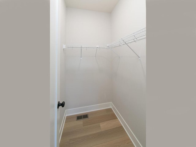 spacious closet featuring visible vents and wood finished floors